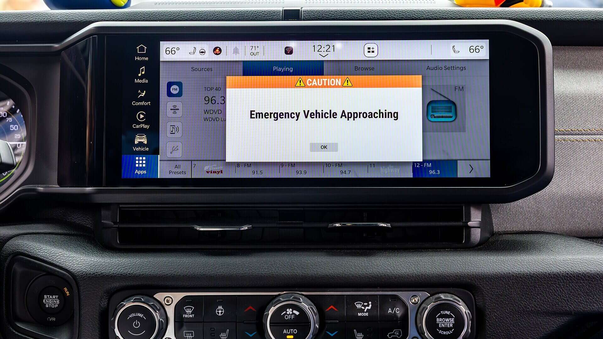 Pantalla de a bordo de un coche conectado con el aviso de un vehículo de emergencia que se aproxima
