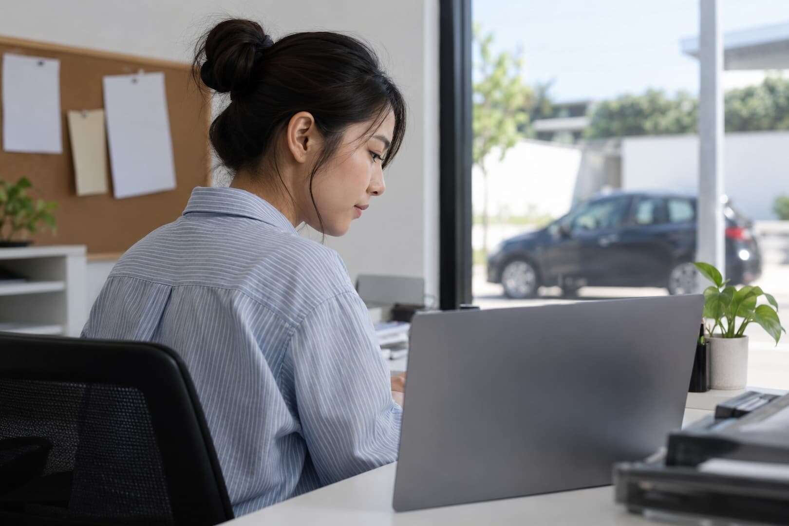 Rental business owner working on a laptop in a small branch office